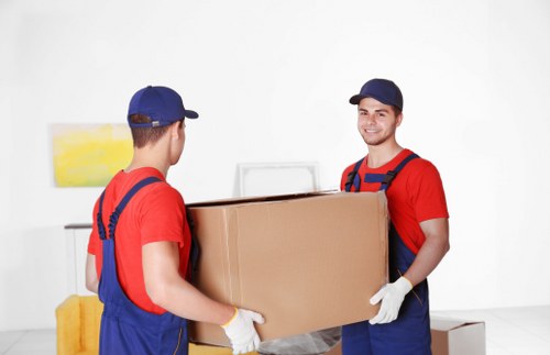 Removal workers handling furniture with care during loading