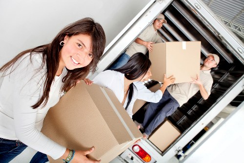 Removal staff handling household items with protective wrapping